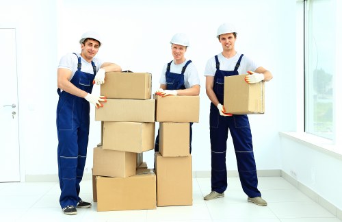 Professional movers carrying items through a Forest Gate flat entrance